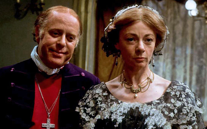 Clive Swift als Bishop Proudie, naast Geraldine McEwan als Mrs. Proudie. Filmstil uit The Barchester Chronicles © BBC 1982 (via IMBD).